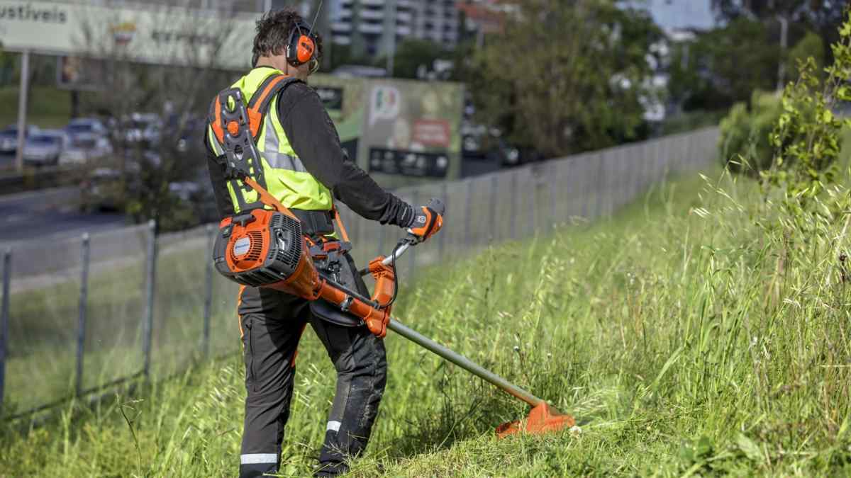 Jardinero trabajando con desbrozadora en Madrid durante labores de mantenimiento de zonas verdes.