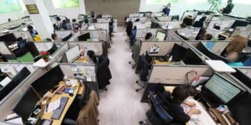 Empleados en oficina de atención al cliente antes de los despidos de Salesforce por la automatización con IA.