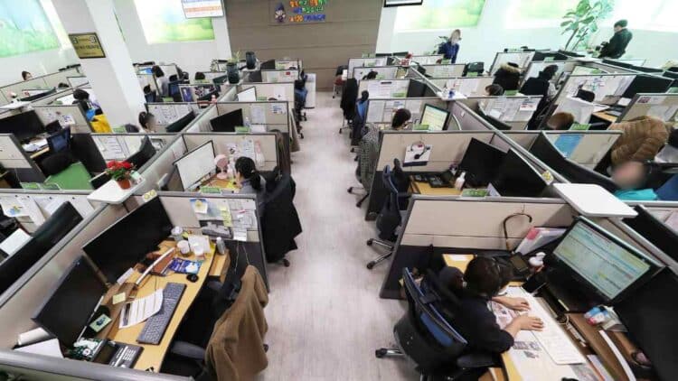 Empleados en oficina de atención al cliente antes de los despidos de Salesforce por la automatización con IA.
