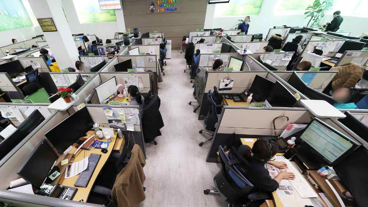 Empleados en oficina de atención al cliente antes de los despidos de Salesforce por la automatización con IA.
