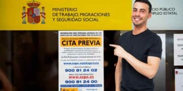 Trabajador del SEPE señalando cartel de cita previa.