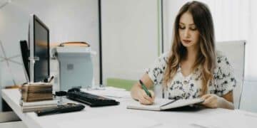 auxiliar administrativo trabajando en oficina con oposiciones 2025.