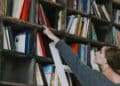técnico auxiliar de biblioteca en Tres Cantos organizando libros.