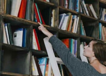 técnico auxiliar de biblioteca en Tres Cantos organizando libros.