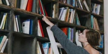 técnico auxiliar de biblioteca en Tres Cantos organizando libros.