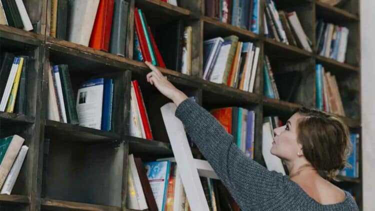 técnico auxiliar de biblioteca en Tres Cantos organizando libros.