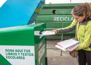 Mujer reciclando libros de texto para conseguir descuento con BOOKCYCLE en la vuelta al cole 2025