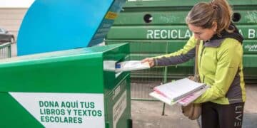 Mujer reciclando libros de texto para conseguir descuento con BOOKCYCLE en la vuelta al cole 2025