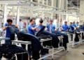 Trabajadores manipulando prendas textiles en una fábrica de Alcalá de Henares para oferta de empleo de Adecco.