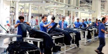 Trabajadores manipulando prendas textiles en una fábrica de Alcalá de Henares para oferta de empleo de Adecco.