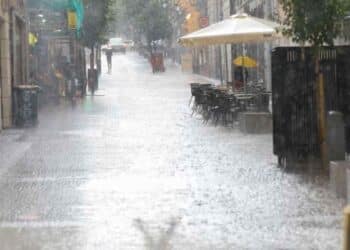 Calle de Madrid bajo lluvia intensa durante la alerta naranja por viento y lluvia.