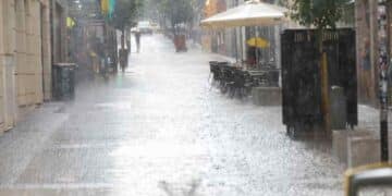 Calle de Madrid bajo lluvia intensa durante la alerta naranja por viento y lluvia.