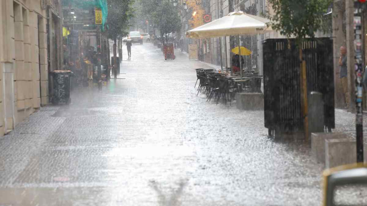 Calle de Madrid bajo lluvia intensa durante la alerta naranja por viento y lluvia.