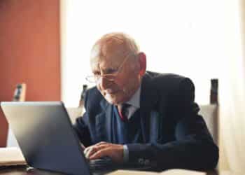 hombre mayor usando ordenador para consultar su pensión y bonificación por jubilación demorada.