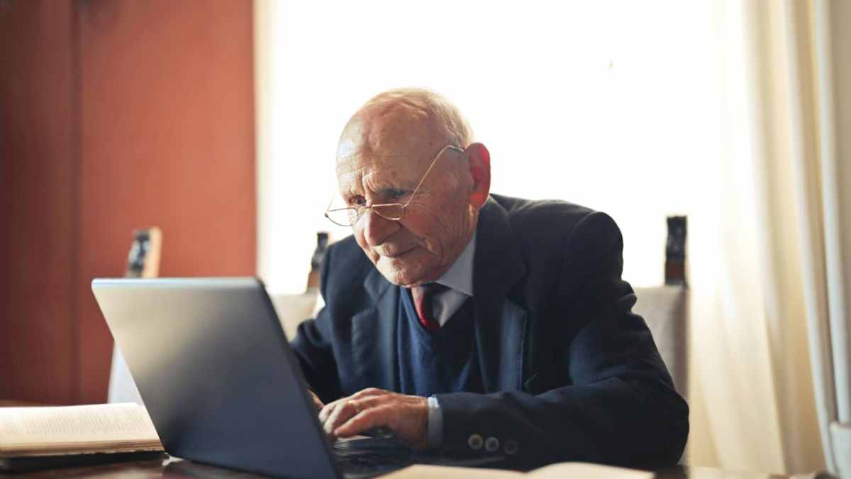 hombre mayor usando ordenador para consultar su pensión y bonificación por jubilación demorada.