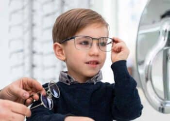 Niño probándose gafas en óptica por la ayuda de 100 euros para gafas infantiles en España.