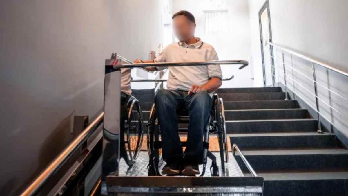 Persona en silla de ruedas usando plataforma salvaescaleras en vivienda adaptada en Alcorcón.