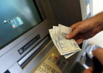 Persona retirando dinero en cajero automático tras nueva norma europea sobre verificación de nombre e IBAN en transferencias.