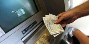 Persona retirando dinero en cajero automático tras nueva norma europea sobre verificación de nombre e IBAN en transferencias.