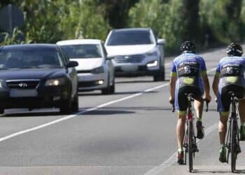 Ciclistas circulando por carretera junto a coches tras cambio de la DGT publicado en el BOE.