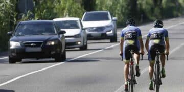Ciclistas circulando por carretera junto a coches tras cambio de la DGT publicado en el BOE.