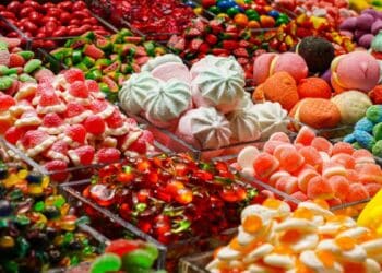 Variedad de caramelos y dulces de colores en exposición, imagen de distribuidora de caramelos en bancarrota durante Halloween.