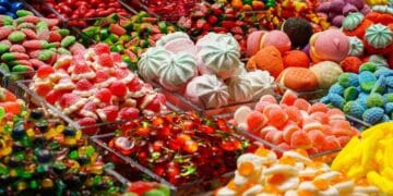 Variedad de caramelos y dulces de colores en exposición, imagen de distribuidora de caramelos en bancarrota durante Halloween.