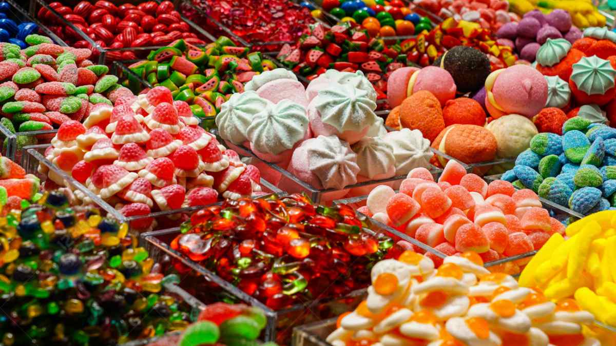 Variedad de caramelos y dulces de colores en exposición, imagen de distribuidora de caramelos en bancarrota durante Halloween.