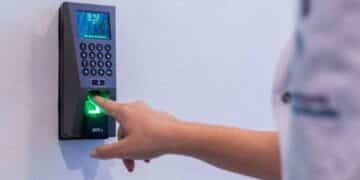 Persona fichando con huella digital en registro horario laboral según el Estatuto de Trabajadores.