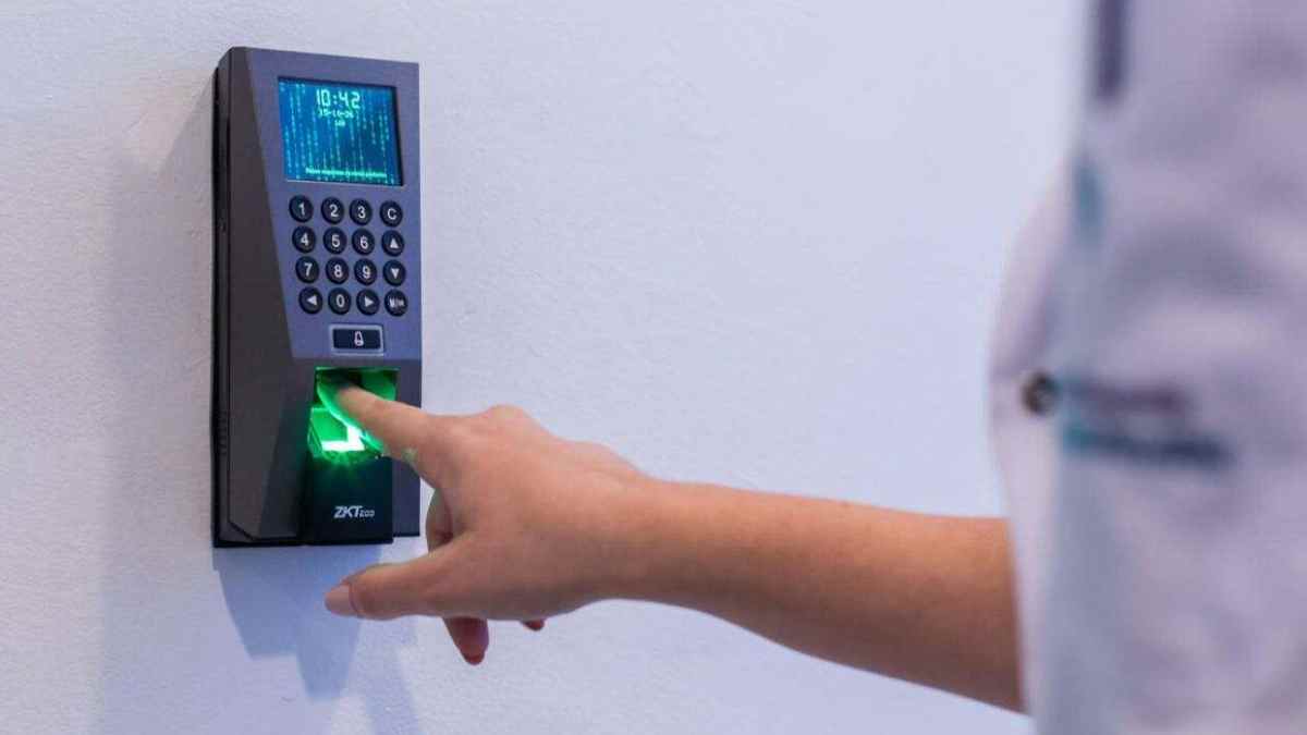 Persona fichando con huella digital en registro horario laboral según el Estatuto de Trabajadores.