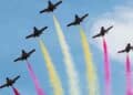 Aviones con estelas rojas y amarillas durante el desfile aéreo del Día de la Fiesta Nacional 2025 en Madrid.