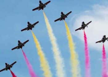 Aviones con estelas rojas y amarillas durante el desfile aéreo del Día de la Fiesta Nacional 2025 en Madrid.