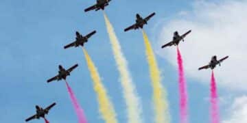 Aviones con estelas rojas y amarillas durante el desfile aéreo del Día de la Fiesta Nacional 2025 en Madrid.