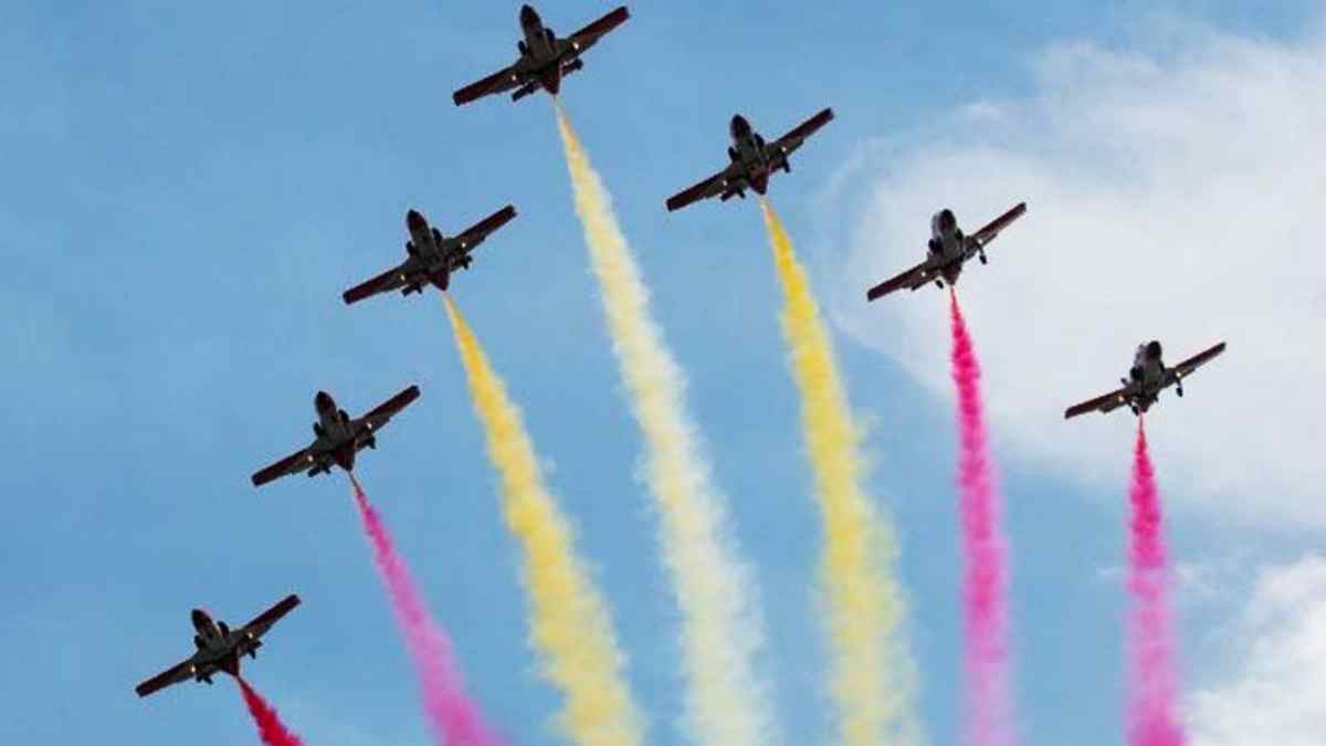 Aviones con estelas rojas y amarillas durante el desfile aéreo del Día de la Fiesta Nacional 2025 en Madrid.