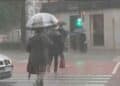 Personas con paraguas caminando bajo la lluvia en Madrid durante las lluvias pasajeras anunciadas por la Aemet.