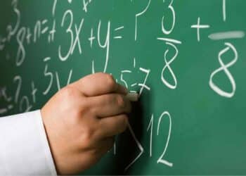 Profesor escribiendo fórmulas en una pizarra durante una clase de Matemáticas en Madrid.