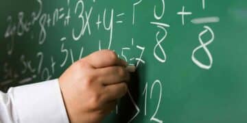 Profesor escribiendo fórmulas en una pizarra durante una clase de Matemáticas en Madrid.