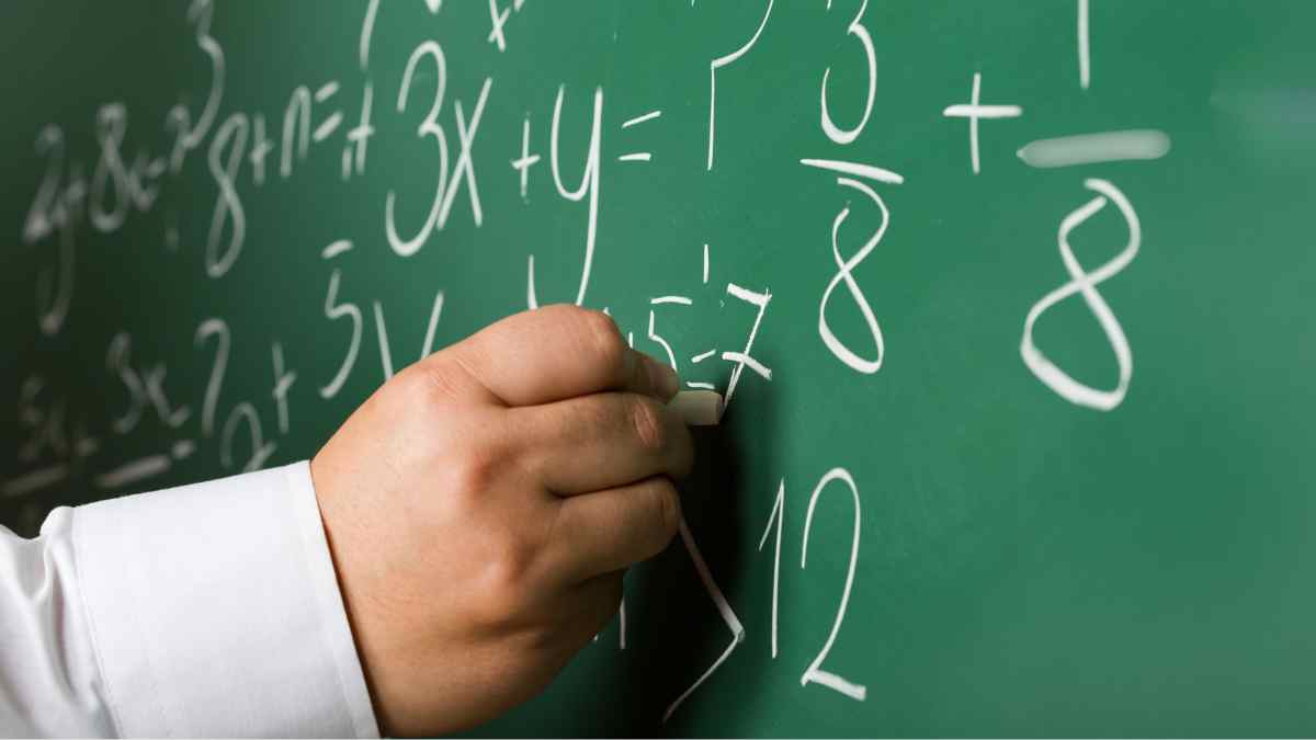 Profesor escribiendo fórmulas en una pizarra durante una clase de Matemáticas en Madrid.