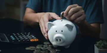 persona ahorrando dinero en una hucha mientras calcula su plan de pensiones.