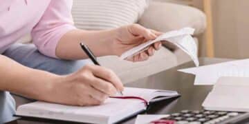 Autónomo revisando facturas y apuntes para aplazar deudas con la Seguridad Social.