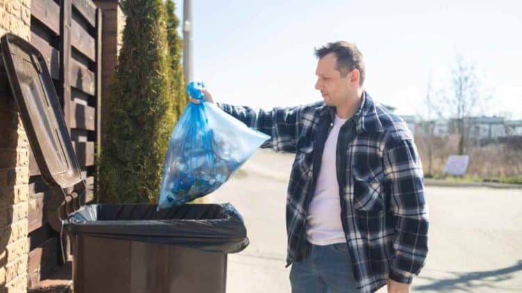 hombre tirando la basura en Madrid por la nueva tasa de residuos 2026.