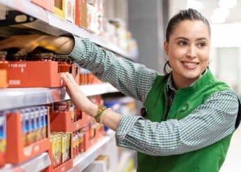 Empleada de Mercadona reponiendo productos en estantería, salario de cajeros y reponedores en 2025.