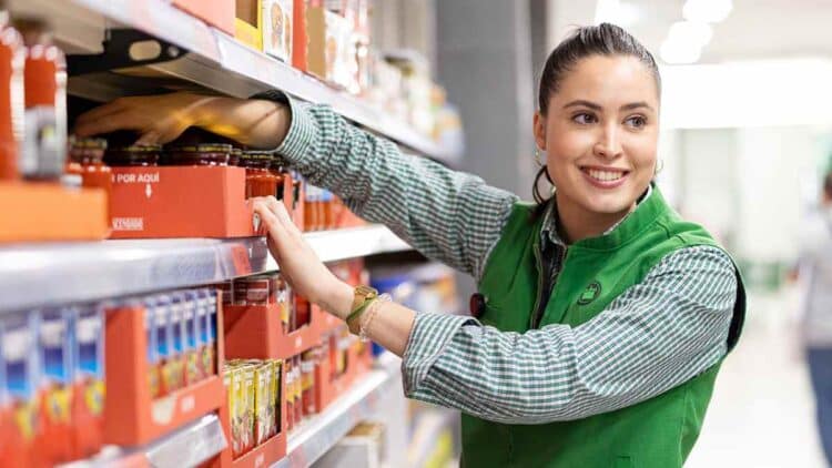 Empleada de Mercadona reponiendo productos en estantería, salario de cajeros y reponedores en 2025.