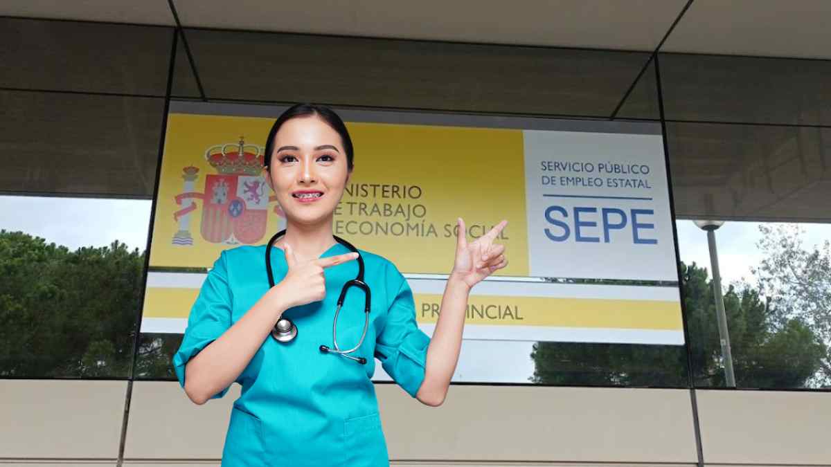 Trabajadora sanitaria frente a una oficina del SEPE con cartel del Ministerio de Trabajo.