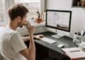 Hombre trabajando desde casa en ordenador por ofertas de empleo remoto del SEPE con contrato indefinido y sueldos de hasta 1.800 euros.