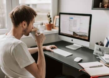 Hombre trabajando desde casa en ordenador por ofertas de empleo remoto del SEPE con contrato indefinido y sueldos de hasta 1.800 euros.
