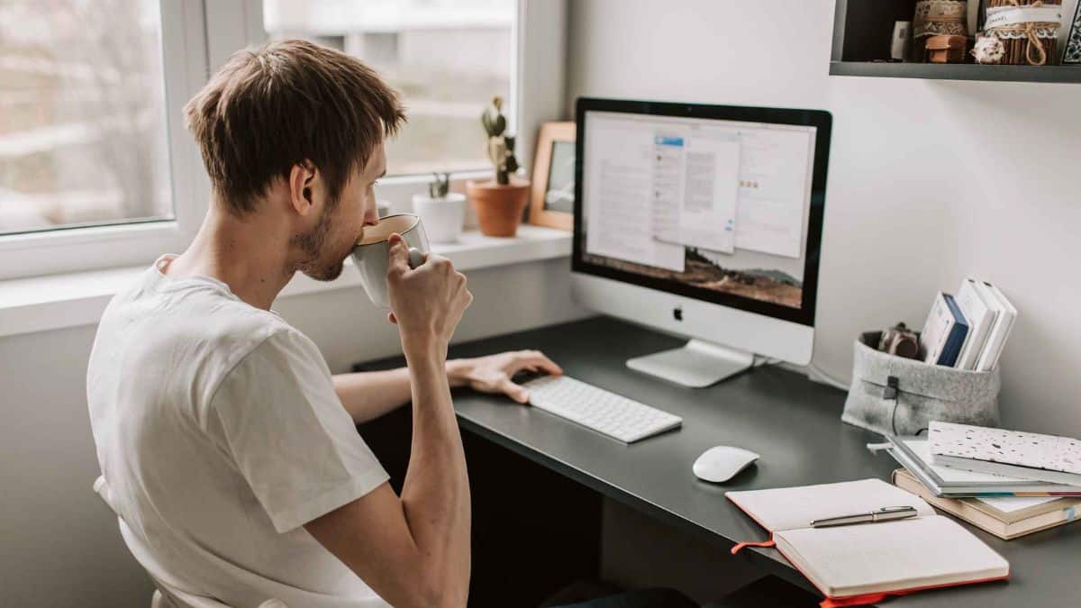 Hombre trabajando desde casa en ordenador por ofertas de empleo remoto del SEPE con contrato indefinido y sueldos de hasta 1.800 euros.