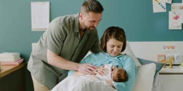 Padres con su bebé recién nacido tras el parto, imagen sobre la suspensión del paro por nacimiento según el SEPE.