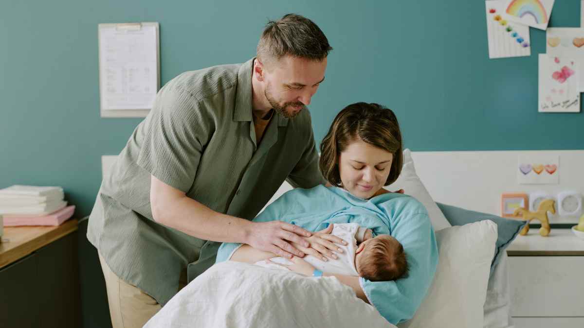 Padres con su bebé recién nacido tras el parto, imagen sobre la suspensión del paro por nacimiento según el SEPE.