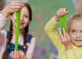 niñas jugando con slime verde casero hecho con cola blanca, detergente y colorante.
